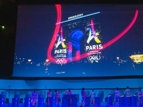 Dancers perform on stage as the Eiffel Tower-shaped bid logo for the Paris 2024 is projected on the Arc de Triomphe on a giant screen during the presentation of Paris as candidate to host the 2024 Olympic Games Wednesday, Feb. 17, 2016. (AP Photo/Francois Mori)