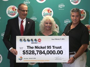 Florida Lottery Secretary Tom Delacenserie, left, presents Maureen Smith and David Kaltschmidt with their one-third share of the Jan. 13, world record Powerball jackpot Wednesday, Feb. 17, 2016, in Tallahassee, Fla. (AP Photo/Steve Cannon)