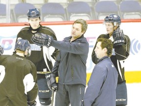 The Flint Firebirds players rallied around coaches John Gruden, centre, and Dave Karpa, right, and got them reinstated, but that likely won?t happen again now that they?ve been fired a second time. (The Associated Press)