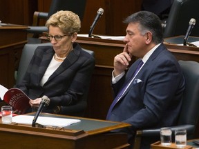 Ontario's Finance Minister Charles Sousa (right) sits with Premier Kathleen Wynne in the legislature on Nov. 26, 2015. (The Canadian Press/Chris Young)