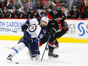 Winnipeg Jets forward Mathieu Perreault (85) tries to control the puck against Carolina Hurricanes forward Eric Staal (12) during the third period at PNC Arena. The Carolina Hurricanes defeated the Winnipeg Jets 2-1. (James Guillory-USA TODAY Sports)