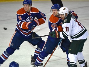 Edmonton Oilers Mark Letestu (55) ties up Minnesota Wild Zach Parise (11) as the puck flies past Mark Fayne (5) during NHL action at Rexall Place on Thursday. (Ed Kaiser)