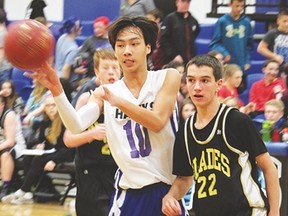 Senior Hawk Justin Wang passes a ball to one of his teammates during the first game in the John Wark Basketball Tournament, against Noble Central, last Friday, Feb. 12 at the Cultural Recreational Centre. The Hawks bested Nobleford 57-47. Derek Wilkinson Vulcan Advocate