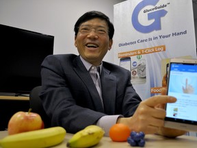 Western University professor Dr. Charles Ling, CEO of GlucoGuide Corp., holds a smartphone running GlucoGuide on February 18, 2016, in London Ont. Developed by Ling and a growing team of 20, GlucoGuide is a diabetes management app that’s attracted $1 million in research and development funding since 2015. CHRIS MONTANINI\LONDONER\POSTMEDIA NETWORK