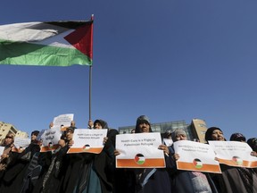 Palestinian women living in Lebanon carry signs and wave a Palestinian flag during a sit-in asking the United Nations Relief and Works Agency for Palestine Refugees in the Near East (UNRWA) for help in improving their living conditions, in front of the U.N. headquarters offices in Beirut, Lebanon January 29, 2016. (REUTERS/Aziz Taher)