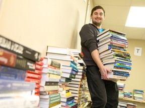 Textbooks line the walls of Textbooks for Change founder Chris Janssen's office at the Goodwill building on White Oaks Road in London, Ont. in this December 18, 2013 file photo.  The books, donated by schools and students, are collected, sorted, and then donated to African universities. (CRAIG GLOVER/The London Free Press/Postmedia Network)