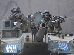 South Korean army soldiers ride a K-1 tank during the annual exercise in Paju, near the border with North Korea, Feb. 19, 2016. (AP Photo/Ahn Young-joon)