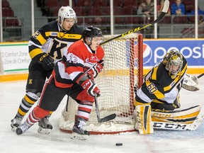 Kingston Frontenacs winger Juho Lammikko (left) chases 67’s winger Artur Tyanulin as goalie Jeremy Helvig looks on Feb. 19. (Wayne Cuddington, Postmedia Network)