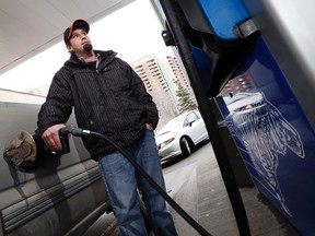 Troy Markwick gases up his truck at the Esso station at Baseline and Pinecrest roads in Ottawa where gas was 69.6 cents per litre, February 3, 2016. (Darren Brown/Postmedia Network)