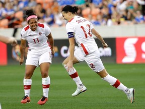 Canada's Christine Sinclair celebrates after scoring a goal with Desiree Scott against Costa Rica during the second half of a CONCACAF Olympic women's soccer qualifying championship semifinal Friday, Feb. 19, 2016, in Houston. Canada won 3-1. (AP Photo/David J. Phillip)