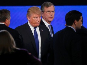 Republican U.S. presidential candidate Donald Trump, centre, passes between rivals Gov. John Kasich, left, former Gov. Jeb Bush, second from right, and U.S. Sen. Marco Rubio, right, at the conclusion of the Republican U.S. presidential candidates debate sponsored by ABC News at Saint Anselm College in Manchester, N.H., on Feb. 6, 2016. (REUTERS/Carlo Allegri)