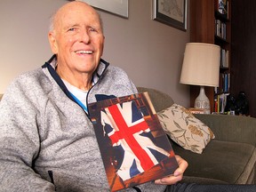 Retired Superior Court judge Gordon Sedgwick, one of the leaders of a well-executed prank perpetrated by 18 Queen's students 60 years ago, holds a framed photo of a Union Jack flag at his Kingston home on  Feb. 11. The flag was one of a half-dozen planted atop flagpoles in four northern New York State communities. (Patrick Kennedy/The  Whig-Standard)