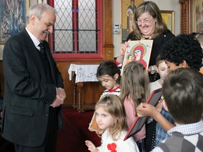 Children show Greece's ambassador to Canada, George Marcantonatos, their painted icons at the Greek Orthodox Church on Johnson Street on Sunday. (Steph Crosier/The Whig-Standard)