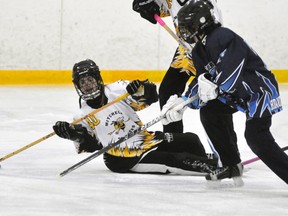 Heather Dearing (40) of the Mitchell U14 ringette team looks for passing options while on her knees during Western Region regular season action in Mitchell Feb. 20. Dearing scored once as Mitchell pulled away late for a 5-1 win. ANDY BADER/MITCHELL ADVOCATE