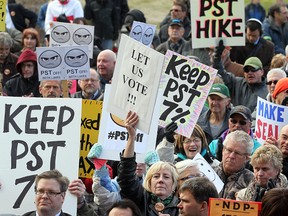 Demonstrators waved placards during a demonstration opposing the hike to the PST at the Manitoba Legislative Building in 2013. (BRIAN DONOGH/WINNIPEG SUN FILE PHOTO)