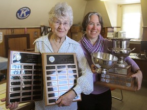 Martha Clarke, left, and Chris Scott, with the Kiwanis Music Festival in Kingston, Ont. on Thursday, Feb. 18, 2016, hold festival trophies as they prepare for next week's event. The number of young musicians attending has been steadily declining. (Michael Lea/The Whig-Standard)