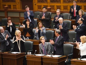 Ontario Premier Kathleen Wynne, bottom centre, receives a standing ovation after issuing an apology regarding a regulation from 1912 that banned elementary school teachers from speaking French during question period at Queen's Park in Toronto on Monday, February 22, 2016. THE CANADIAN PRESS/Nathan Denette