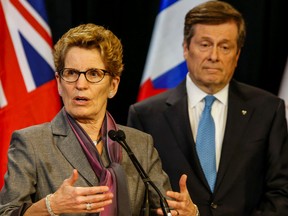 Premier Kathleen Wynne addresses the media while Toronto Mayor John Tory listens during his visit to Queen's Park Monday, February 22, 2016. (Dave Thomas/Toronto Sun)