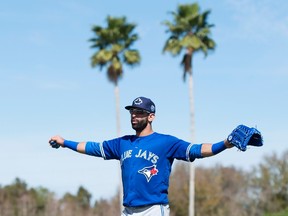 Toronto Blue Jays outfielder Jose Bautista stretches his arms as he walks up the field in the first official workout of spring training in Dunedin, Fla., on Feb. 22, 2016. (THE CANADIAN PRESS/Frank Gunn)