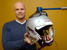 Physiotherapist Theodore Versteegh shows off his device, called Topspin 360, mounted on a football helmet. The weighted, swivelling arm is intended to help athletes strengthen their neck muscles to prevent concussions. (MORRIS LAMONT, The London Free Press)