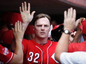 Cincinnati Reds' Jay Bruce celebrates in the dugout after scoring on a sacrifice fly by Tucker Barnhart in the second inning of a game against the Pittsburgh Pirates in Cincinnati on Sept. 7, 2015. (AP Photo/John Minchillo)