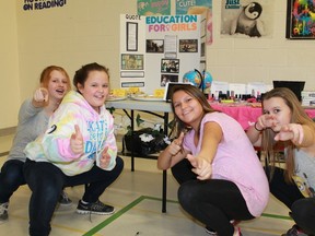 P.E. McGibbon grade six students Rachel Brooks, Leigha Maitland, Gabby Brooks and Tera Laforge strike a pose in front of their display regarding girls' education on Friday, Feb. 12. The group has sent letters to the federal government and Ontario colleges demanding that Ontario college-based schools present in Saudi Arabia open their doors to girl students. 
CARL HNATYSHYN/SARNIA THIS WEEK