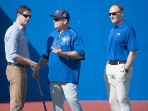 Toronto Blue Jays GM Ross Atkins, left, manager John Gibbons and president and CEO Mark Shapiro chat while watching the first official workout of spring training in Dunedin, Fla., on Feb. 22, 2016. (Frank Gunn/The Canadian Press)
