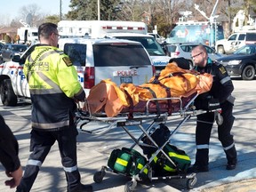 A victim is taken away on a stretcher following a stabbing incident at Dunbarton High School in Pickering, Ont., on Feb. 23, 2016. (Salvatore Sacco/the Canadian Press)