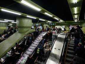 Commuters use escalators leading to a platform in a subway station in Hong Kong on February 26, 2014. (AFP PHOTO/Philippe Lopez)