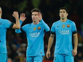 Barcelona’s Lionel Messi (middle) goes to celebrate with teammate Javier Mascherano following the end of the Champions League match against Arsenal at the Emirates Stadium in London, Tuesday, Feb. 23, 2016. (AP Photo/Matt Dunham)