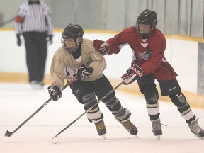 Players from the Warriors (left) and Rolling Stones battle during 3-on-3 bantam hockey at Canlan Ice Sports on Ellice Avenue on Sat., May 25, 2013.