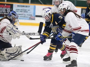 Notre Dame Alouettes Ashley McKerral tries to get her stick on the loose puck as St. Charles Cardinals goalie Cheyenne Bates-Saucier tries for the save and Cards defenceman Grace Racicot comes in on the play during senior girls division 1 championship round action in Sudbury, Ont. on Tuesday February 23, 2016.
