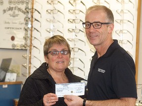 Wallaceburg Splash Pad committee member Deadra Kilbride accepts a $1,000 donation from New Vision Optical's Brad Eggett. Eggett is making the donation to mark his 25th anniversary of his business in downtown Wallaceburg.
