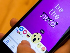 In this Thursday, Feb. 18, 2016 photo taken in New York, Julie Zhuo, product design director at Facebook, demonstrates Reactions - the new emoji-like stickers customers will be able to press in addition to the "Like" button. (AP Photo/Mary Altaffer)