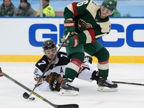 Wild left wing Jason Zucker (right) keeps the puck away from Blackhawks defenceman Brent Seabrook during second period NHL Stadium Series action in Minneapolis on Sunday, Feb. 21, 2016. (Craig Lassig/AP Photo)