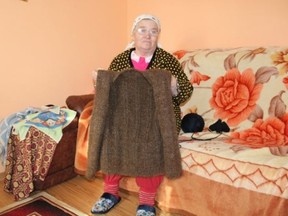 Ortansa Pascariu from Romania poses with a coat knitted from her own hair, that she had saved for 20 years. (Handout/Postmedia Network)