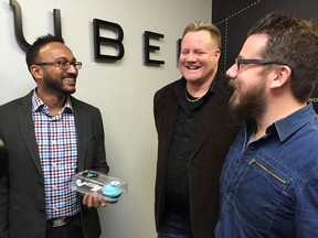 Uber Alberta's general manager Ramit Kar celebrates one year of Uber in Edmonton with driver Derryn Donaghey, middle, and Grant Sanderson, general manager of MKT on Whyte Avenue. Photo taken at the Uber office in Edmonton on Thursday, Jan. 14, 2016. Elise Stolte/Postmedia Network