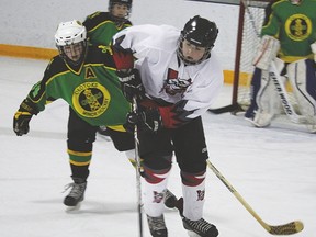 Peewee Hawk Joel Campbell steals the puck away from an advancing Okotoks player before taking a shot on net. The peewee squad shut out Okotoks 6-0 at the Vulcan District Arena last Saturday during a playoff game. Derek Wilkinson Vulcan Advocate