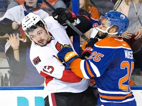Ottawa Senators ' Nick Holden is checked by Edmonton Oilers' Darnell Nurse during second-period NHL action at Rexall Place in Edmonton on  Feb. 23, 2016. (THE CANADIAN PRESS/Jason Franson)