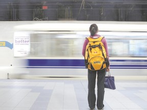 A University of Alberta student stands on the platform at the school?s underground light rail transit station as one of the electrically powered trains zips by. (Postmedia News File)