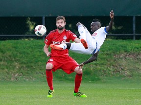 Montreal Impact defender Ambroise Oyongo goes airborne to clear the ball away from a Toronto FC opponent during last night’s friendly at Clearwater. (Kim Klement/USA Today Sports)
