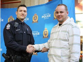 Const. Sasa Novakovic shakes hands with the Good Samaritan, Eugene DeRose, who helped save him from an attacker on Feb. 17, 2016. Novakovic was pinned by an attacker when DeRose jumped out of his car and put the man in a headlock. (Claire Theobald photo)