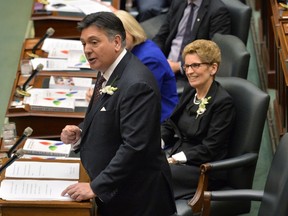 Ontario Finance Minister Charles Sousa, left, delivers the Ontario 2016 budget next to Premier Kathleen Wynne, right, at Queen's Park in Toronto on Thursday, February 25, 2016. THE CANADIAN PRESS/Nathan Denette