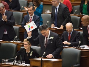 Ontario Finance Minister Charles Sousa, right, delivers the Ontario 2016 budget next to Premier Kathleen Wynne, left, at Queen's Park in Toronto on Thursday, February 25, 2016. THE CANADIAN PRESS/Nathan Denette