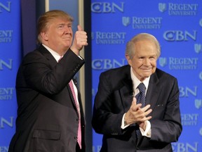 Republican presidential candidate Donald Trump, accompanied by Rev. Pat Robertson, gives a thumbs up to the crowd after speaking at Regent University in Virginia Beach, Va., Wednesday, Feb. 24, 2016.  (AP Photo/Steve Helber)