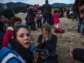 A Syrian woman reacts after her arrival with other refugees and migrants from the Turkish coast to Mytilene on the Greek island of Lesbos, Tuesday, Feb. 23, 2016.  Nearly 100,000 migrants and refugees have traveled to Greek islands from nearby Turkey so far this year. (AP Photo/Manu Brabo)