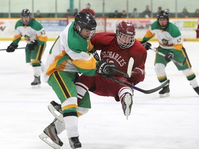 Josh Favaro, left, of the Lockerby Vikings, knocks Tayler Bedard, of St. Charles Cardinals, to the ice during boys high school hockey final action at the Gerry McCrory Countryside Sports Complex in Sudbury, Ont. on Thursday February 25, 2016.