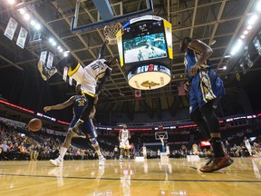 London Lightning player Warren Ward (10) follows up his dunk by hanging from the rim after beating Saint John Mill Rats players Jean-Richard Volcy and Johnny Mayhane down the length of the court during their NBL Canada basketball game at Budweiser Gardens in London, Ont. on Thursday February 4, 2016. (CRAIG GLOVER, The London Free Press)