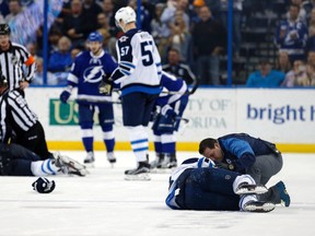 Winnipeg Jets' Bryan Little is attended to by a trainer after a hit from Tampa Bay Lightning's Anton Stralman on Feb. 18 in Tampa, Fla. (AP Photo/Mike Carlson)