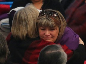 Bernice Smith, sister of missing woman Claudette Osborne, is hugged by federal Indigenous Affairs minister Caroline Bennett during a blanket ceremony for missing and murdered aboriginal women in Winnipeg on Thursday. (Brian Donogh/Winnipeg Sun)
